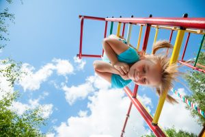 Low angle view of cute blond girl wearing blue tshirt hanging fr